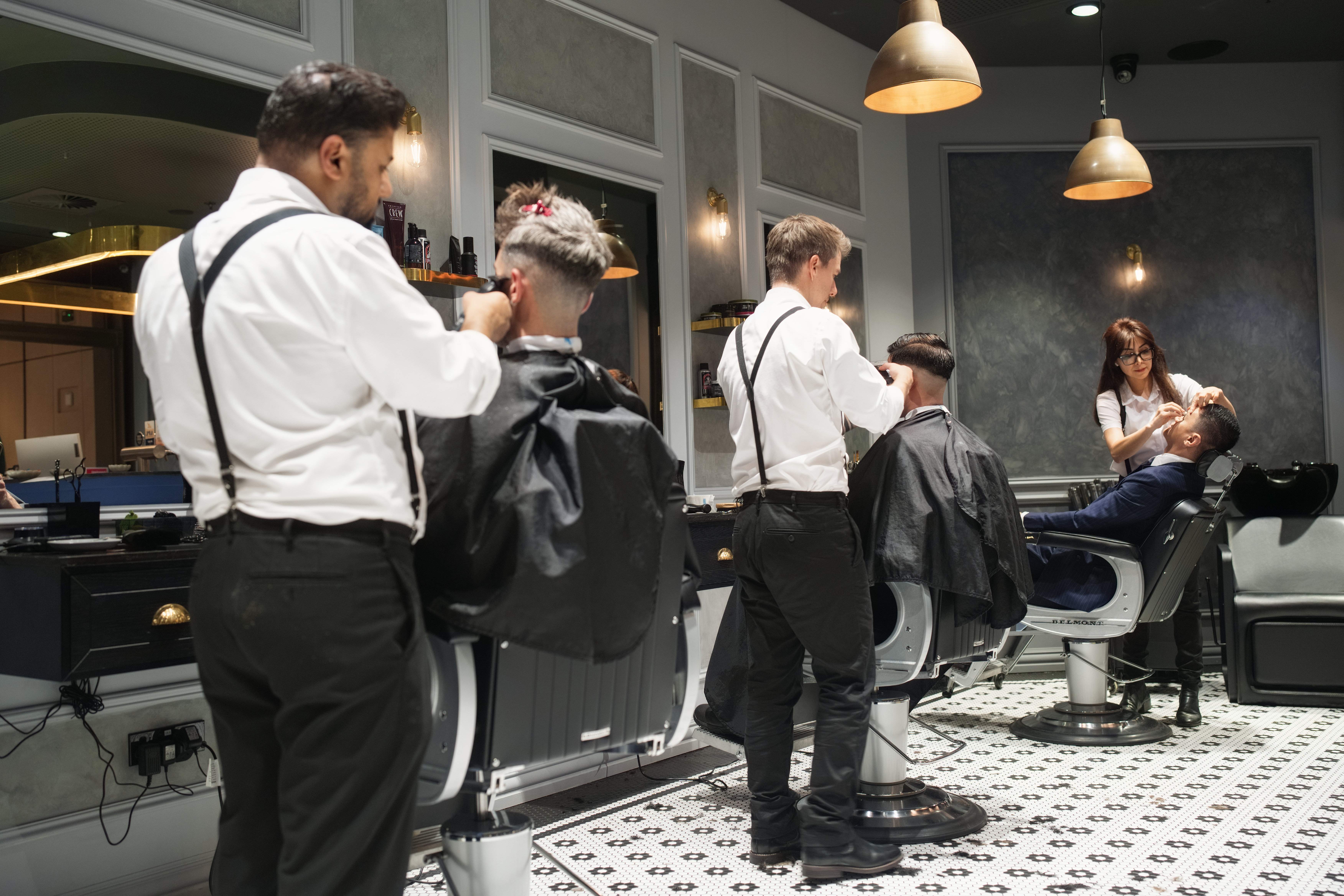 Professional barbers working with clients