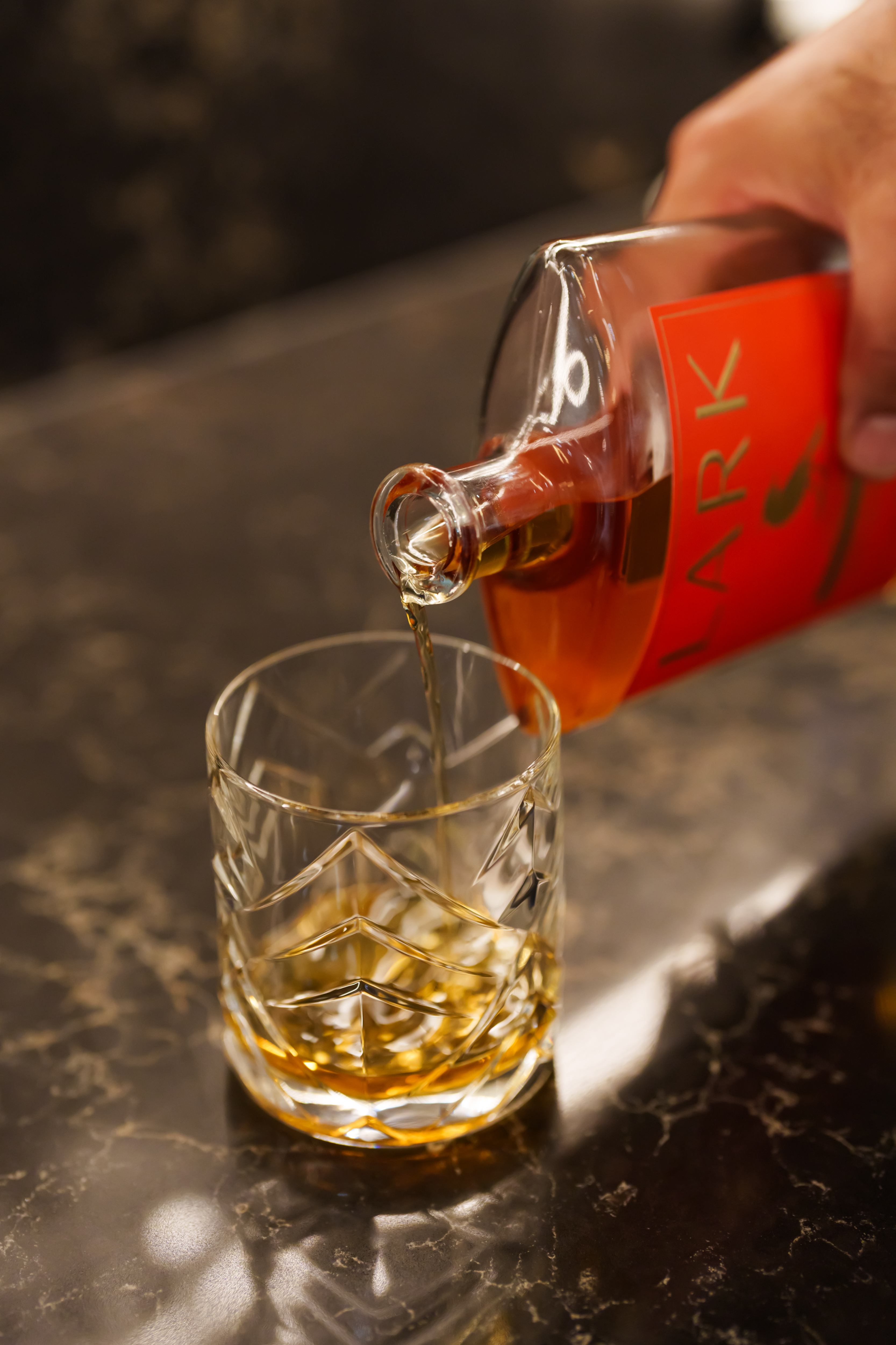Pouring whiskey into crystal glass at the bar