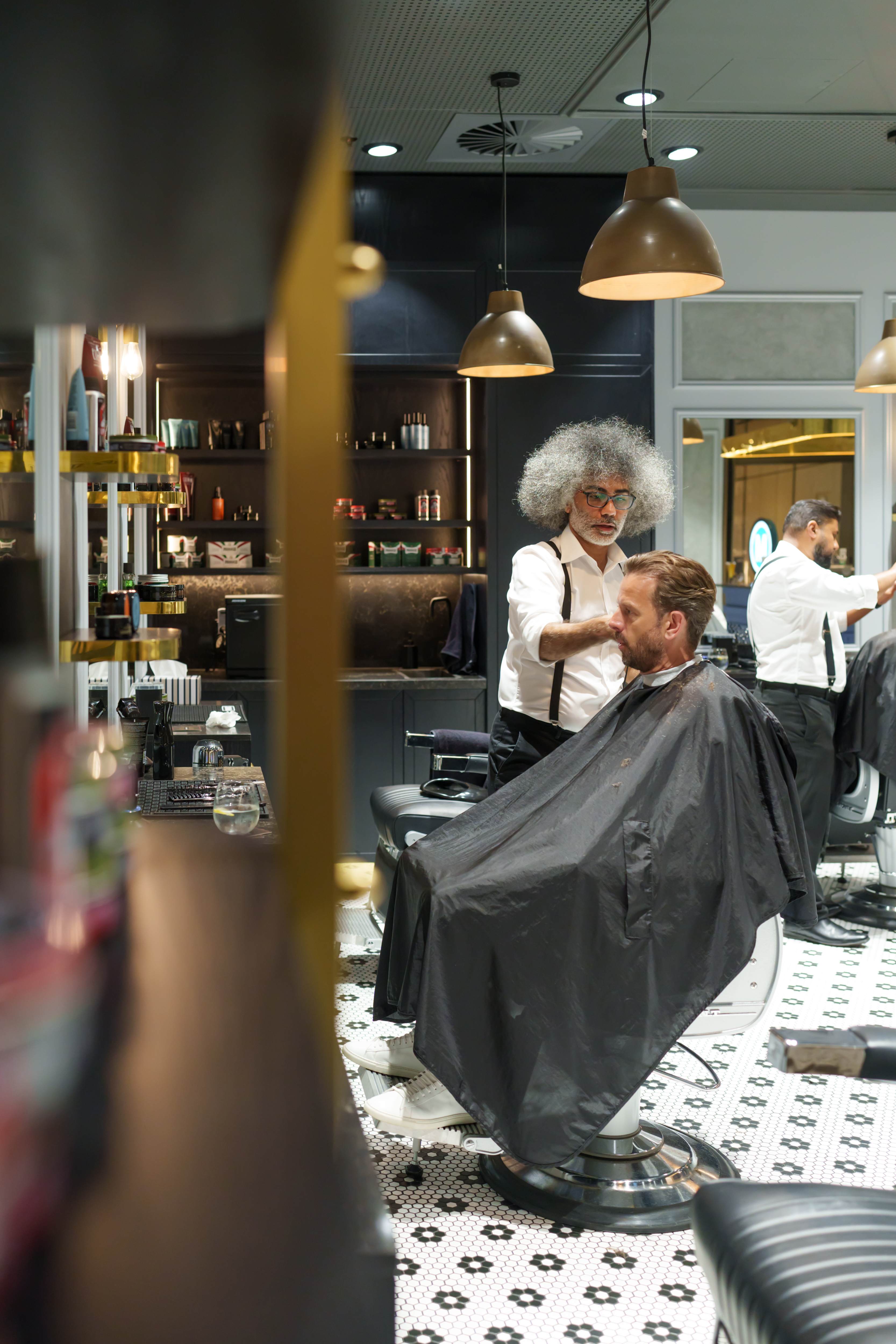 Barbershop interior with barber styling client